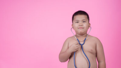 obese boy who is overweight pink background