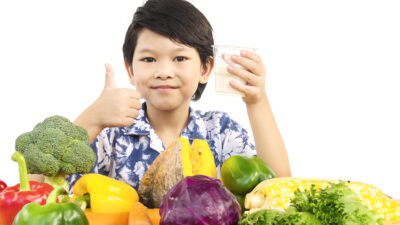 asian healthy boy showing happy expression with glass milk variety fresh vegetable
