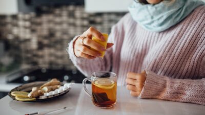 female hands squeezing lemon her tea