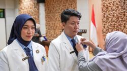 Pemasangan pin IAI secara simbolis oleh Dewas NTB apt Dra Gita Suciati kepada apoteker baru Unram