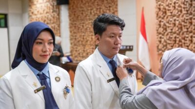 Pemasangan pin IAI secara simbolis oleh Dewas NTB apt Dra Gita Suciati kepada apoteker baru Unram