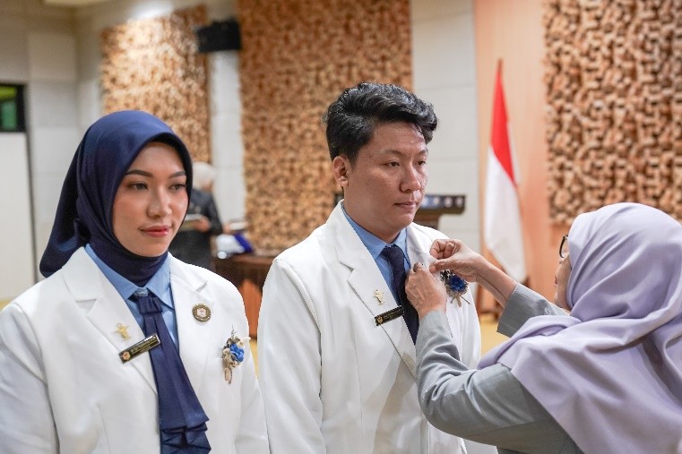Pemasangan pin IAI secara simbolis oleh Dewas NTB apt Dra Gita Suciati kepada apoteker baru Unram